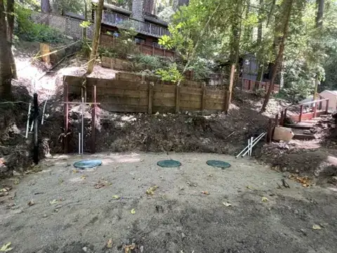 Completed three-tank septic system installation on a hillside property