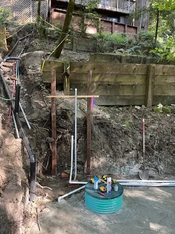 Multi-tank septic excavation underway on a hillside property